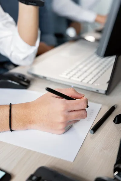 A stack of official letters on a kitchen table next to a pen and a cup of coffee, morning light through the window.