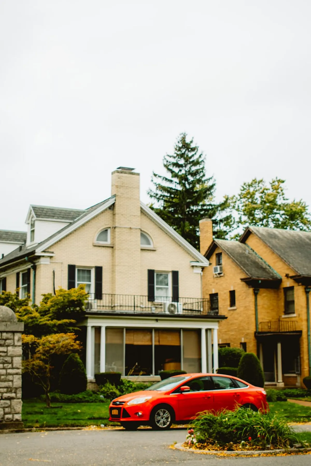 Two homes side by side: a warm residential house on one side and a larger multi-story community building on the other.