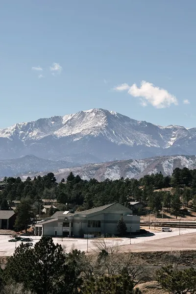 A Colorado mountain home with a wide deck and views of the Rocky Mountains in the background.