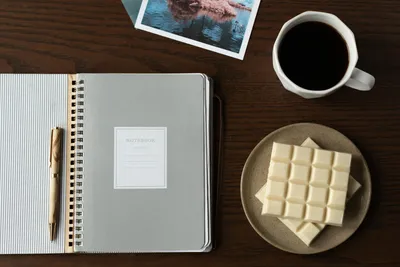 Two notebooks open on a kitchen table with handwritten notes comparing two care homes.