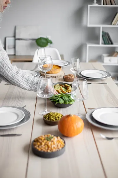 A caregiver preparing a balanced meal in a bright home kitchen with fresh vegetables on the counter.
