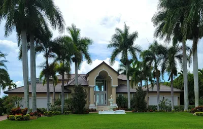 A Florida ranch-style home with palm trees and a screened front porch.