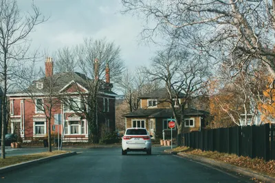 A brick bungalow on a tree-lined Chicago neighborhood street with a front porch and flower boxes.