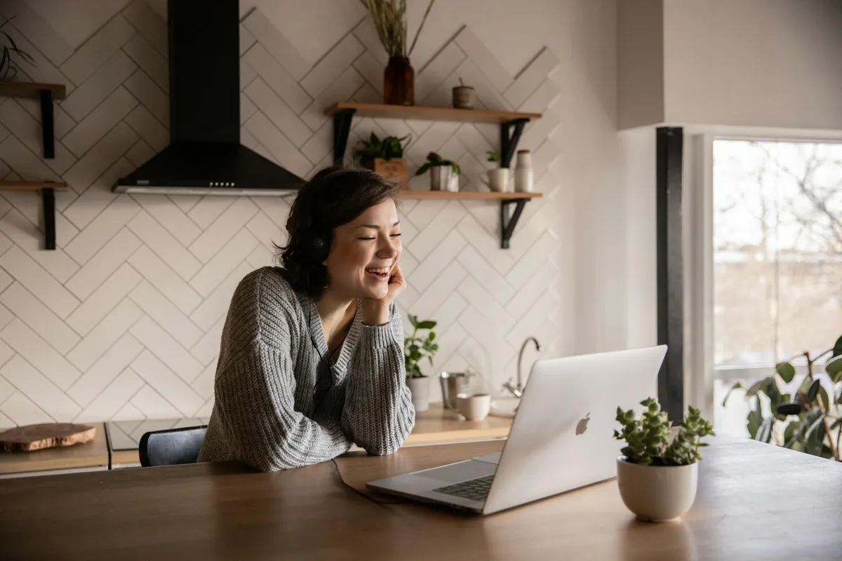 A laptop showing a video call with multiple family members, set on a dining table with notes.
