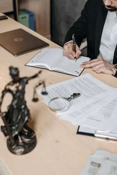 An elder law attorney reviewing trust documents with an older couple across a desk in a bright office.