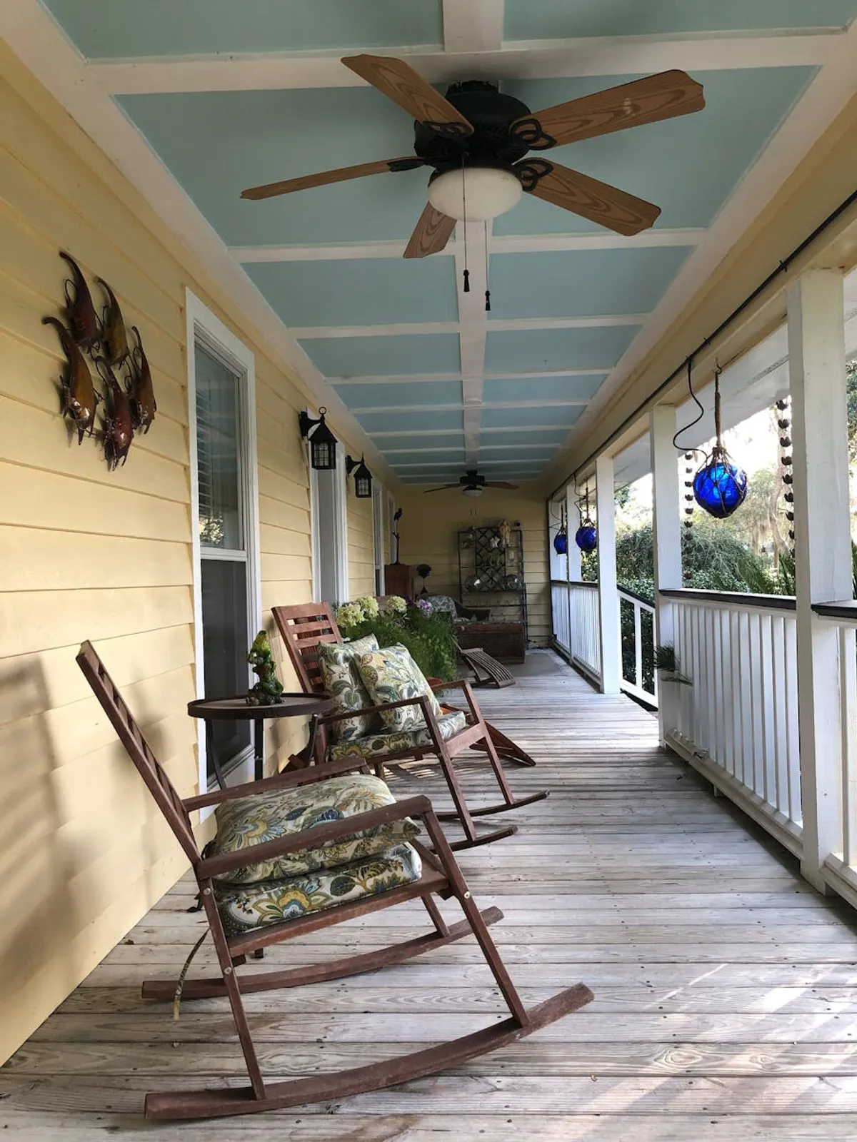 A Lowcountry-style home in South Carolina with a wide porch, palmetto trees, and Spanish moss.