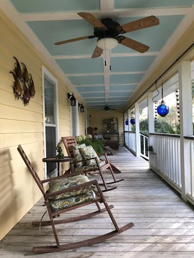 A Lowcountry-style home in South Carolina with a wide porch, palmetto trees, and Spanish moss.
