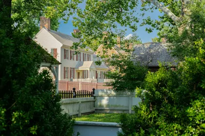 A brick colonial home with white shutters and a garden path in a Virginia neighborhood.